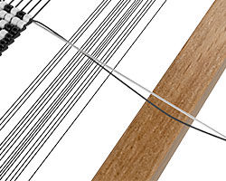 two lines of thread leading off of the loom from the end of the pattern.